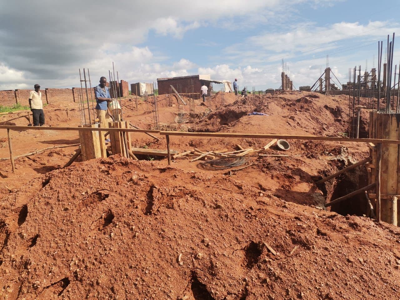Column formwork installation.Foundation phase — column formwork installation. Timber formwork was fixed around the reinforced column bases in preparation for concrete casting, while excavated soil was heaped along the trench edges on site.