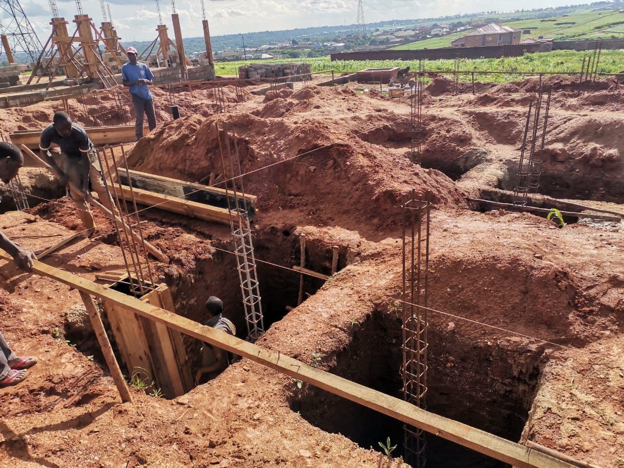 Column base excavation and reinforcement. Trenches were excavated for the foundation, and reinforced steel columns (rebar cages) were installed with their concrete bases cast. The next step was casting the ground beams and backfilling.